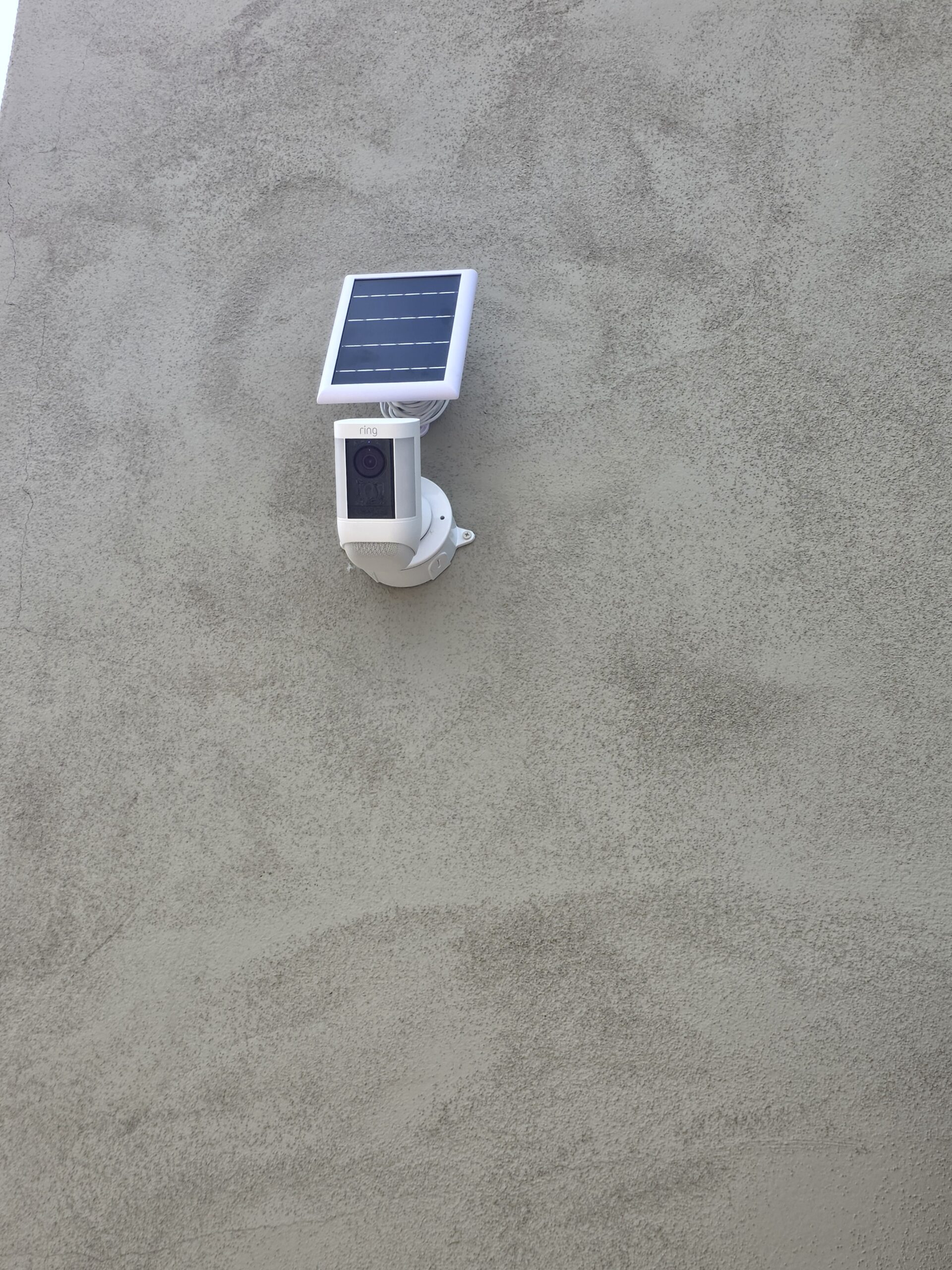 Ring solar-powered security camera mounted on exterior wall